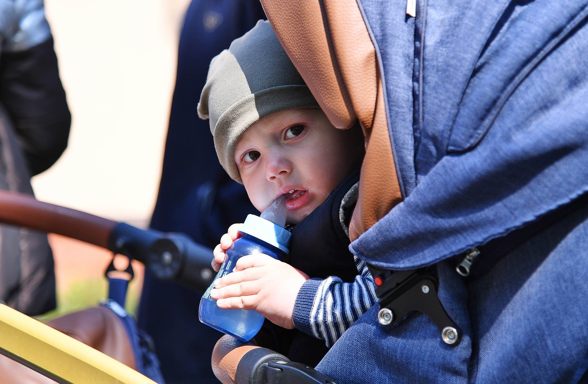 Ребенок в коляске в очереди у пункта выдачи гуманитарной помощи