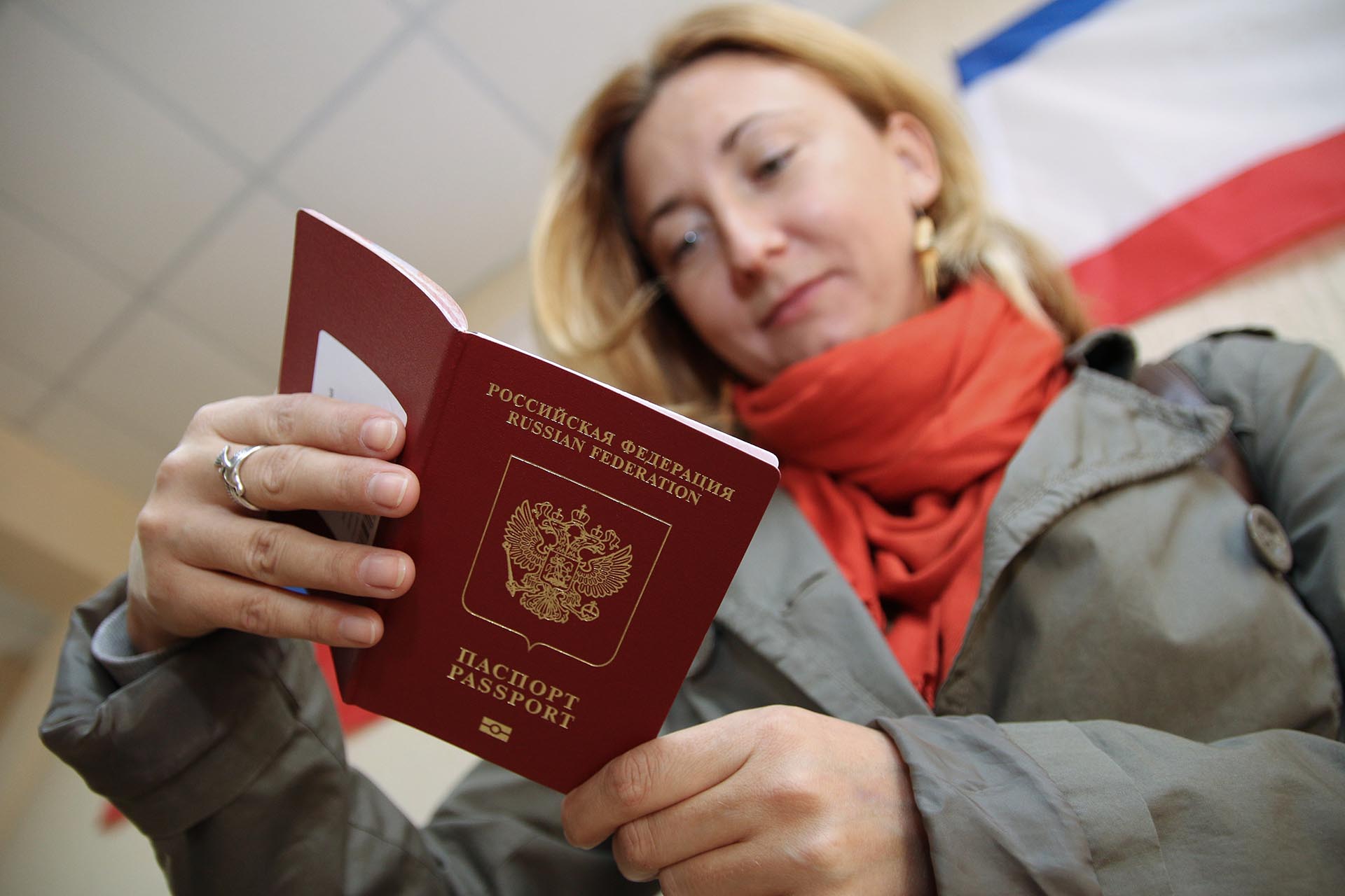 Женщина держит в руках заграничный паспорт РФ