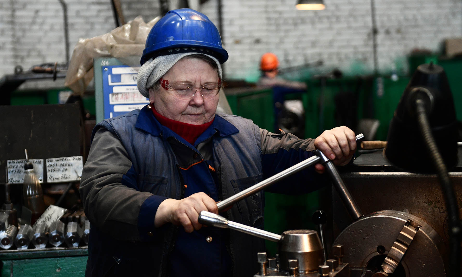 Женщина за токарным станком в цехе завода химического машиностроения