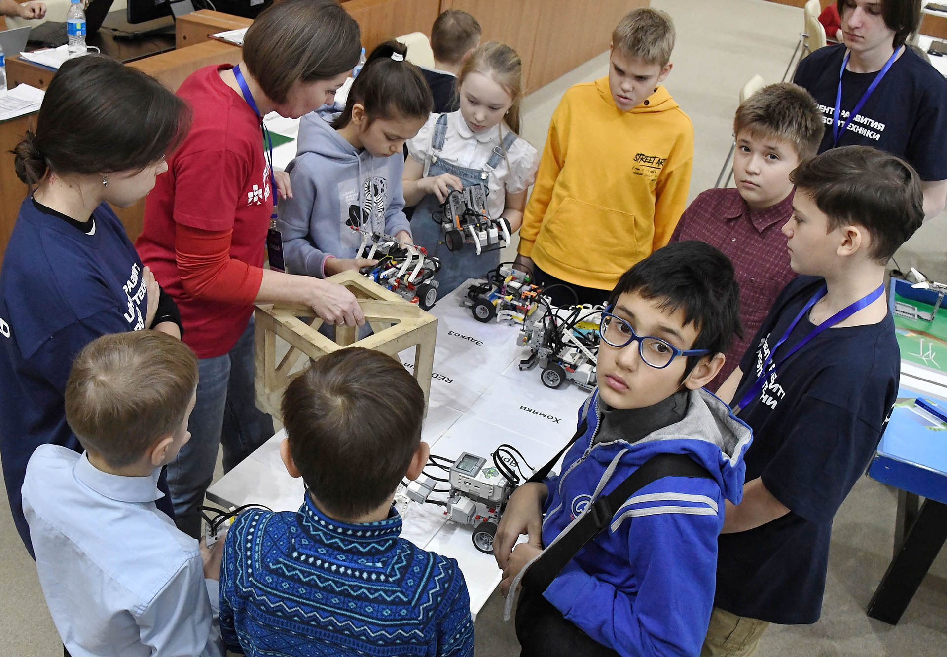 Дети за общим столом собирают роботов