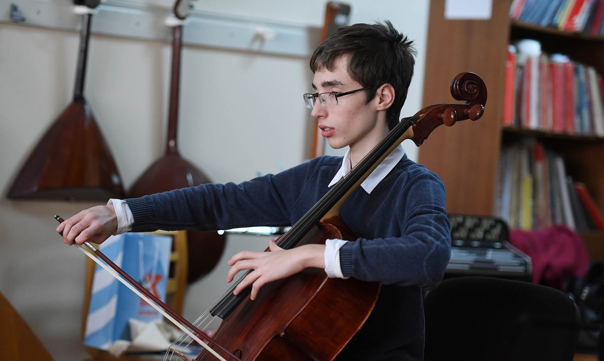 Студент музыкант на занятии по классу виолончели