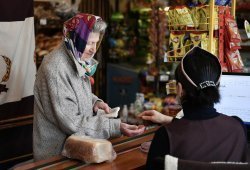 Пожилая женщина в магазине на кассе