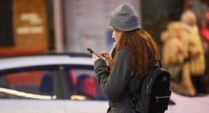 Женщина с телефоном на одной из улиц города