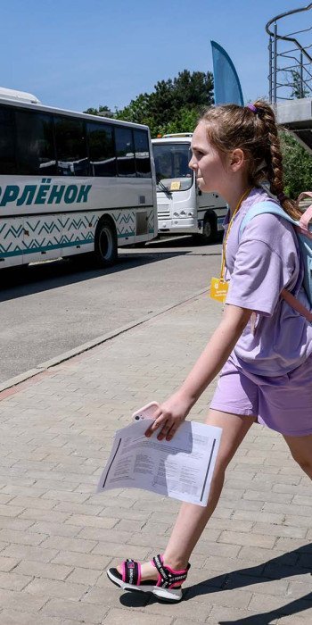 Девочка с чемоданом около автобуса на территории Всероссийского детского центра "Орленок"