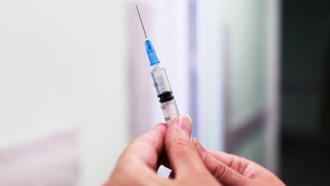 Шприц с вакциной во время профилактической вакцинации